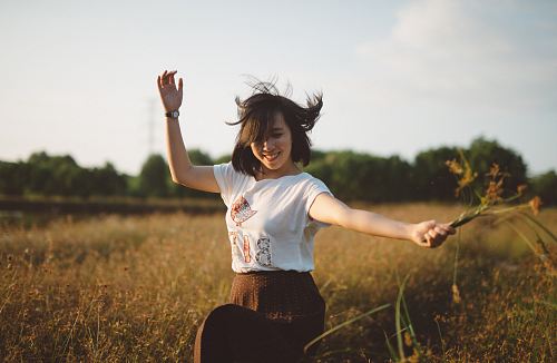woman holding flower on field