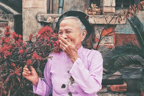 woman holding red petaled flowers