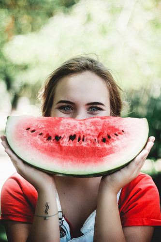 woman holding sliced watermelon
