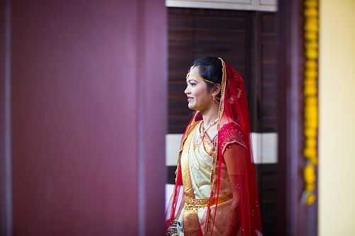 woman in sari dress standing near purple wall