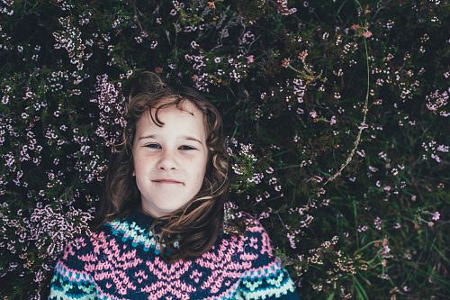 woman laying on green grassfield