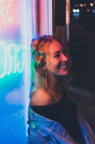 woman leaning on neon signage