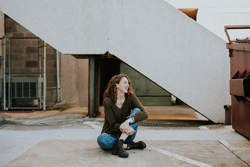 woman sitting near concrete staircase