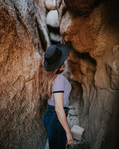woman standing between narrow cave pathway