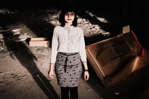 woman wearing gray long-sleeved shirt and gray skirt standing