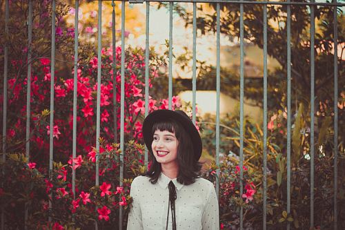 women's white dress shirt standing gray fence