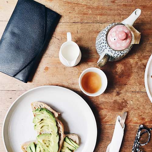 breakfast black leather long wallet beside plate avocado