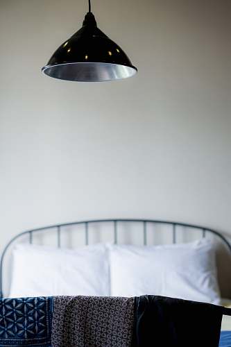 room selective focus photography of textile under pendant lamp inside well-lit room bedroom