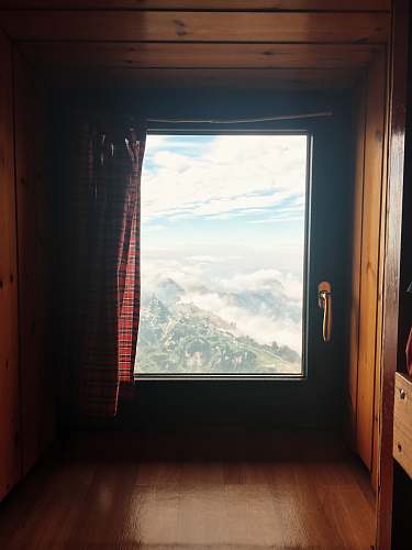 veneto closed black wooden framed window with red plaid curtain italia