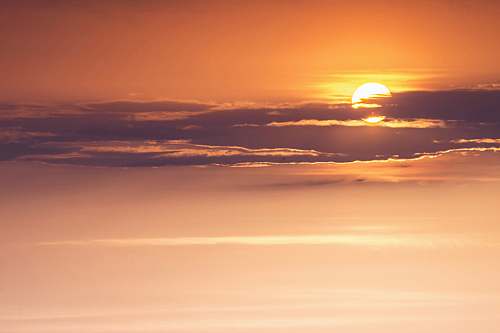 outdoors orange sun behind clouds sky
