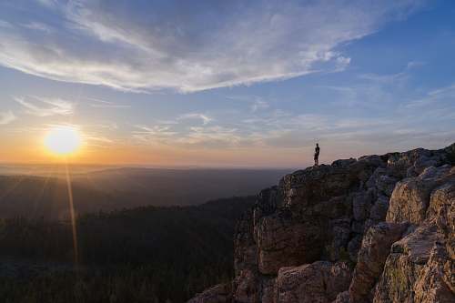 sun person standing on mountain cliff view