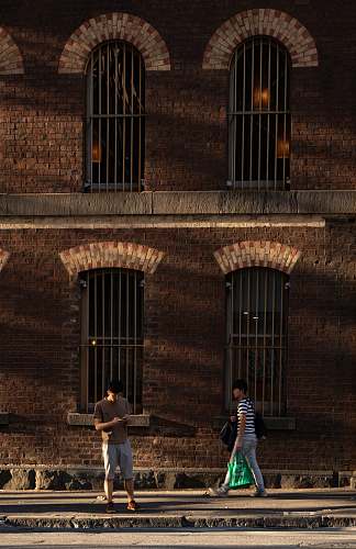 human two men standing near brown building path