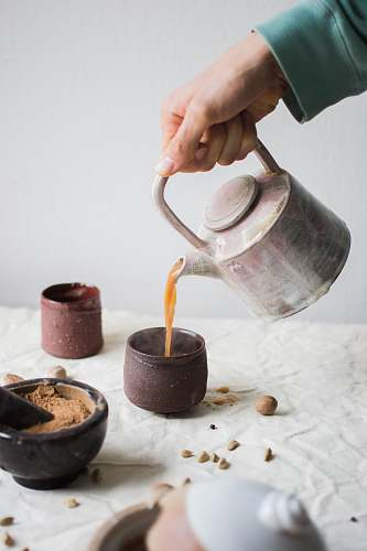 human person pouring coffee on brown cup person
