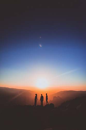 nature silhouette of three person standing on mountain outdoors