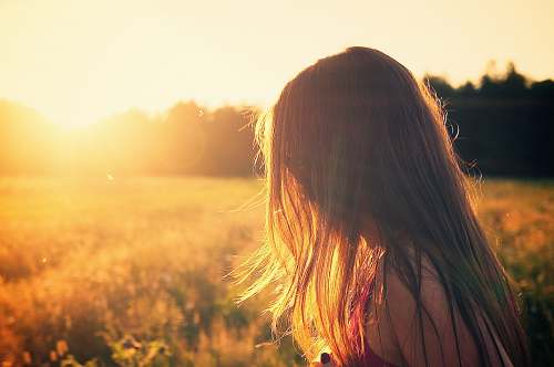 girl woman wearing black camisole top walking on grass field during sunrise woman