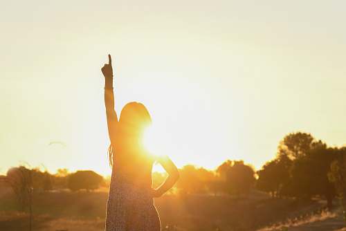 flare woman pointing on ttop near tree light