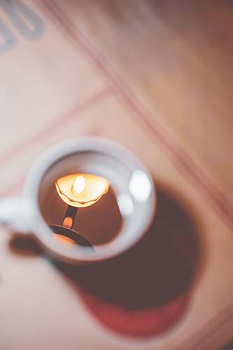 candle selective focus photo of teacup depth of field