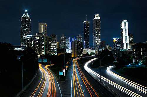 building time lapse photo of passing cars during night time night