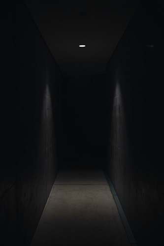 dark dark pathway lit with small light fixture horror