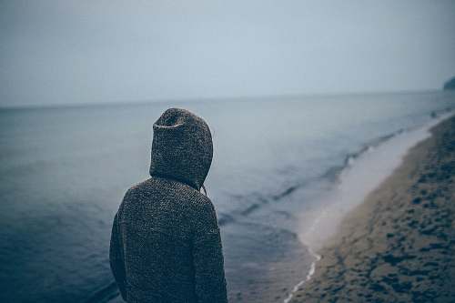 sea person standing beside seashore sea shore