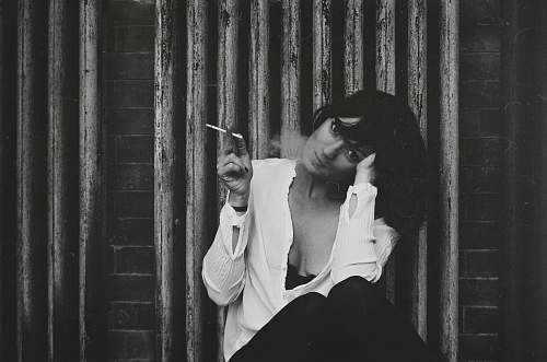 person grayscale photo of a woman holding a cigarette people