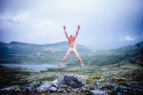 person woman in white bikini lying on rock near body of water during daytime dance pose