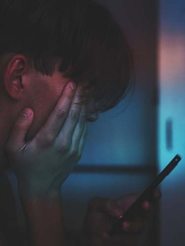 human man holding smartphone in close up photography blue