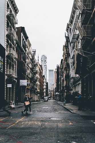 a street with buildings and people walking down it