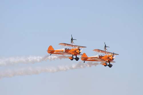 biplane photo of two orange flying biplanes airplane