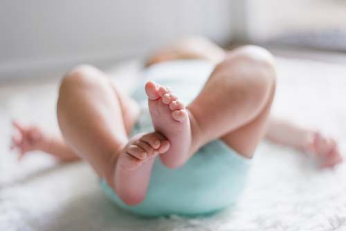 people baby laying on bed kid