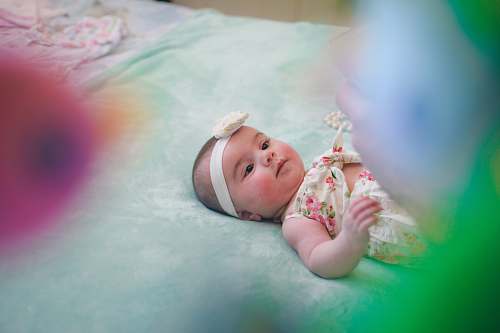human baby wearing pink and beige floral onesie newborn