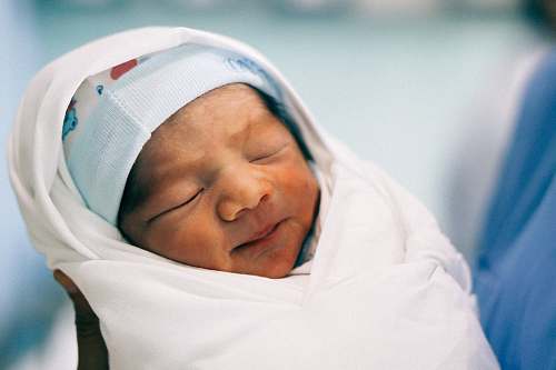 human baby's covered with white swaddle person