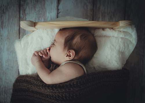 person baby's sleeping on white comforter human