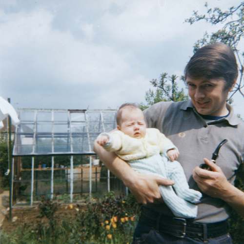 human man in grey polo shirt holding baby person