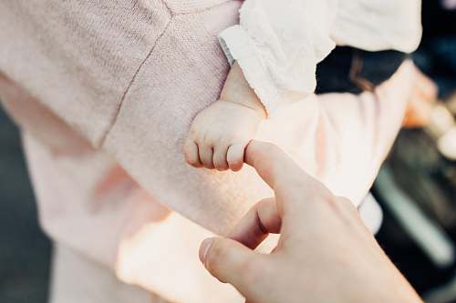 human person holding baby's hand person