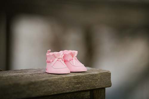 shoe selective focus photography of pink shoes on wooden bench pink