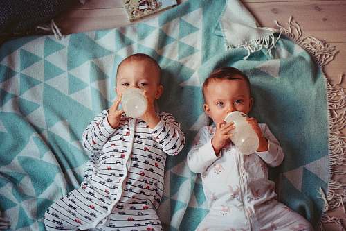 people two babies lying on teal textile human