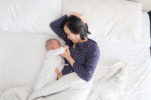 child woman and baby lying on bed bed