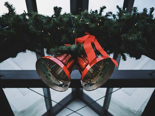 flora two red steel bells beside green Christmas decoration bells
