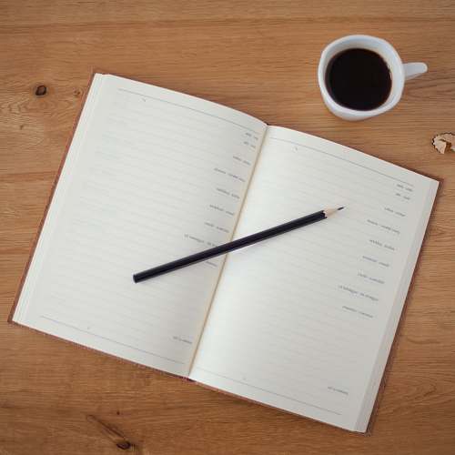 work black pencil on top of ruled paper writing