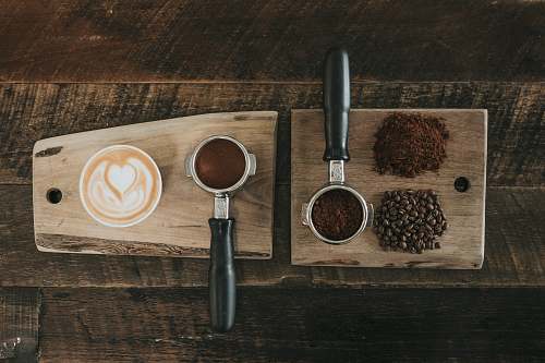 nature coffee beans beside coffee powder on brown wooden board countryside