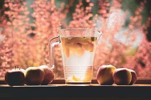fruit clear glass pitcher filled with clear liquid selective focus photography apple