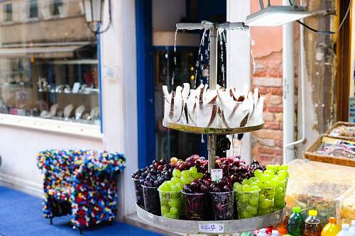sweets displayed fruits outside white and brown building during daytime confectionery