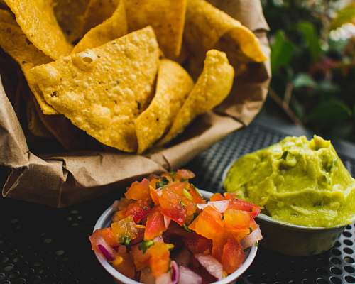 nachos fried crackers with red tomatoes and green sauce bowl