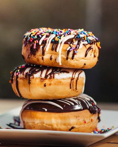 dessert three chocolate-coated donuts with sprinkles pastry