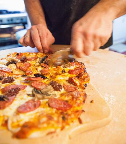 pizza unknown person slicing pizza human
