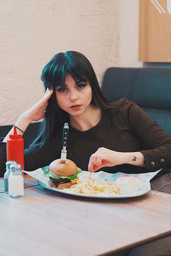 burger woman sitting in front of tray of food human