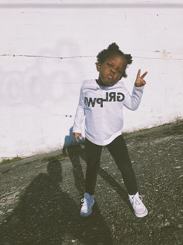 girl wearing white and black sweater doing peace hand sign