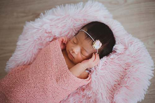 baby baby sleeping on pink fur pad newborn