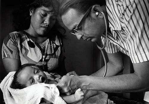 person doctor checking baby black-and-white